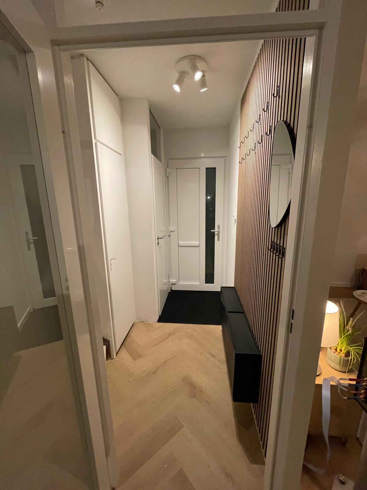 Hal met houten lattenwand en visgraat-vloer