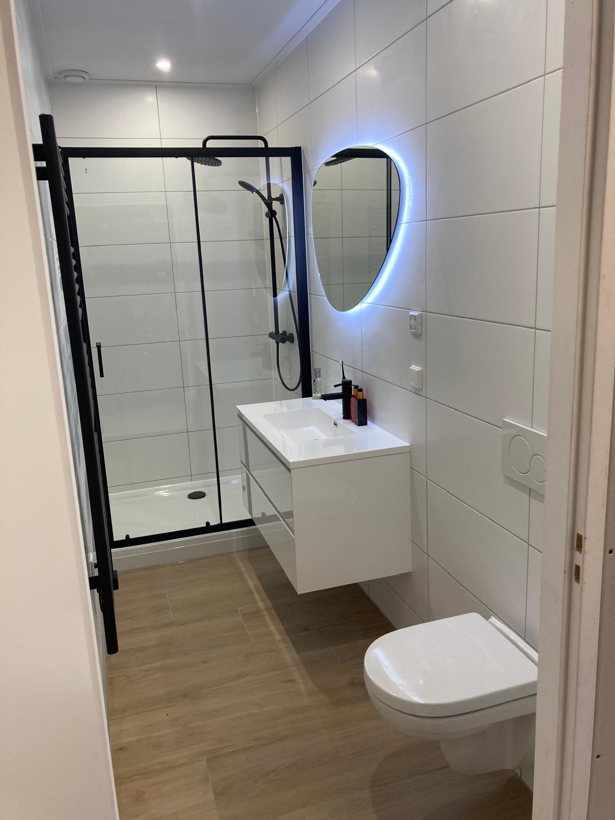Lichte badkamer met inloopdouche en ovale spiegel